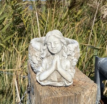 Biddende engel van polyresin in grijze steenlook op gedenkplek
