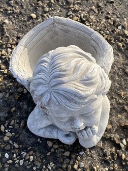 Detail engel beeldje van cement met rustige uitstraling