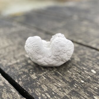 Achterzijde van een handgemaakt herdenkingsbeeldje van een baby engel