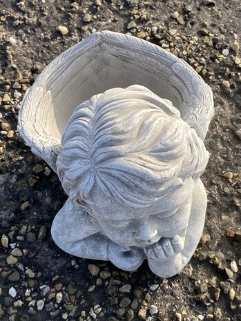 Detail engel beeldje van cement met rustige uitstraling