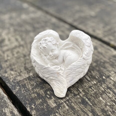 Klein herdenkingsbeeldje van een baby engel in hartvormige vleugels, handgemaakt van beton