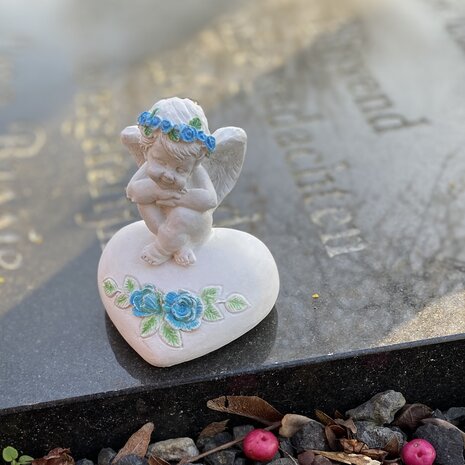 Detail van handgemaakt herdenkbeeldje engel met blauwe bloemen